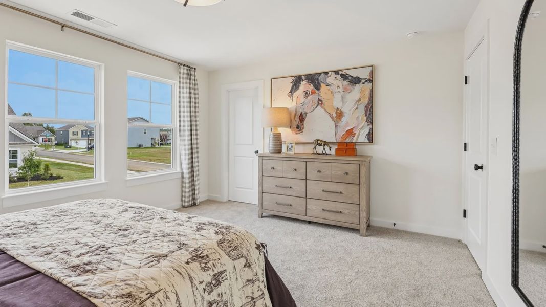 Secondary bedroom with carpet, closet, and window
