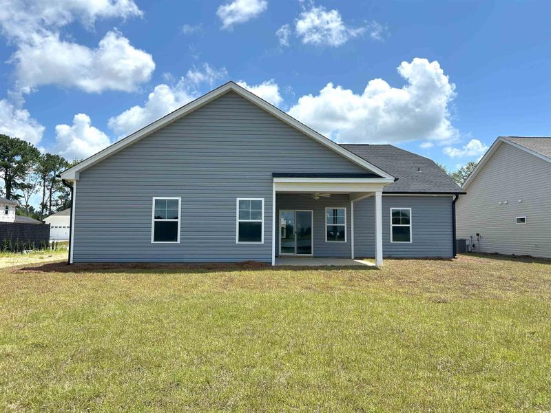 Back of house with a yard and a patio area