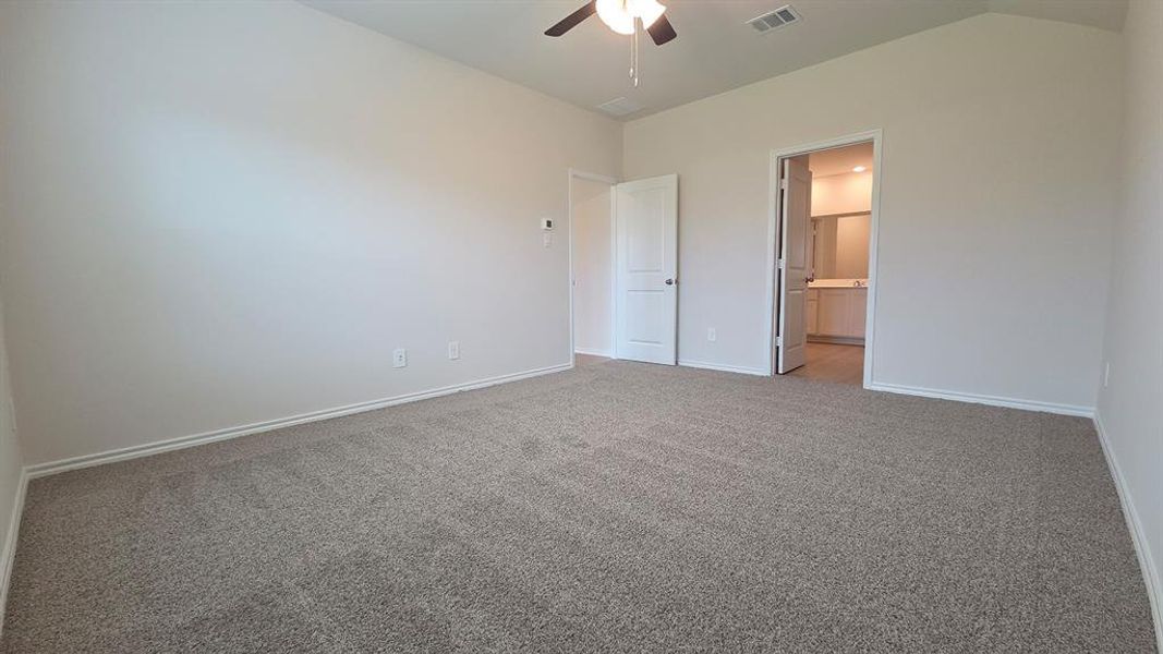 Spacious room featuring neutral carpet flooring, light-toned walls, a ceiling fan, and white trim