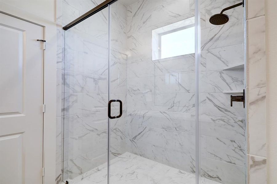 The primary bath features a largewalk-in shower with durable andsleek tile extending to the ceiling.