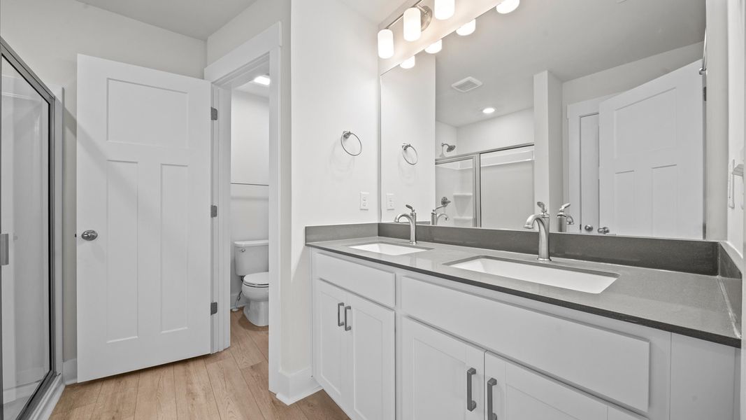 Highly functional and elegant en-suite with dual vanities, walk-in shower, and refined finishes Highly functional and elegant en-suite with dual vanities, walk-in shower, and refined finishes