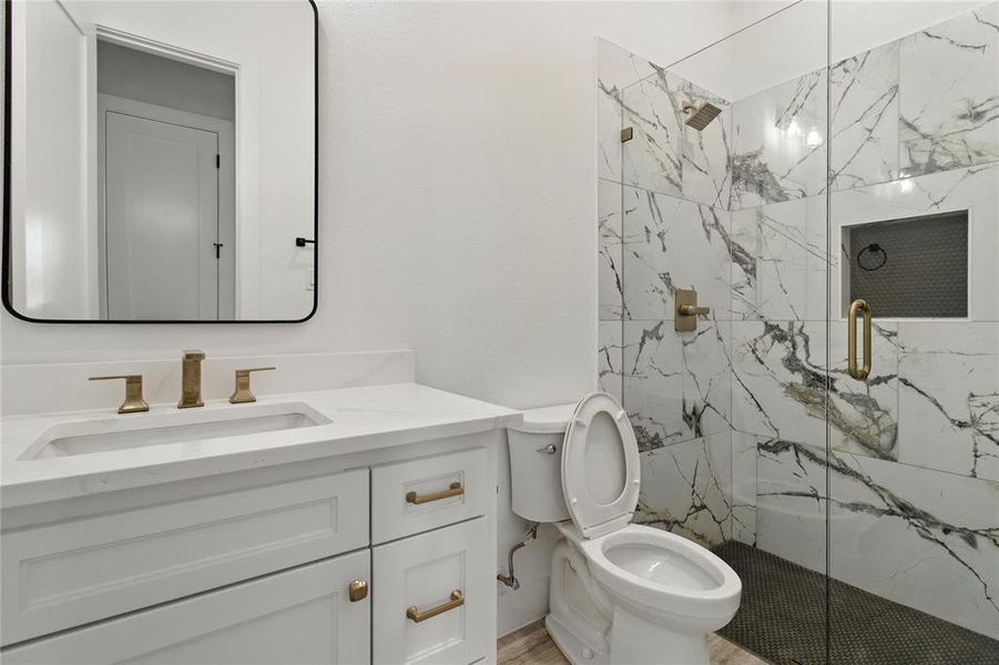 Bathroom featuring a marble finish shower and vanity Bathroom featuring a marble finish shower and vanity