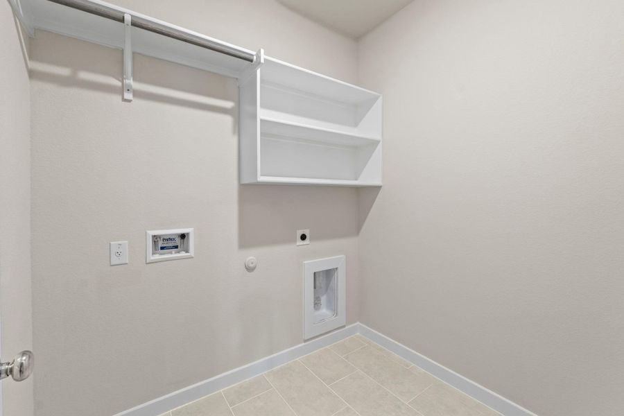 A well-appointed utility room featuring ample shelving and a convenient hanging rod.