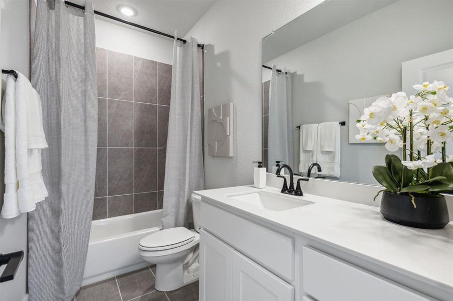 Full bathroom featuring toilet, shower / bath combo, vanity, and tile patterned flooring