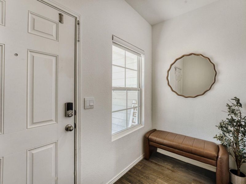 Doorway with wood finished floors and a textured wall