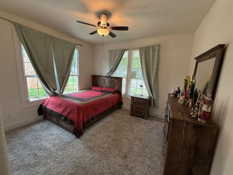 Carpeted bedroom featuring baseboards and a ceiling fan