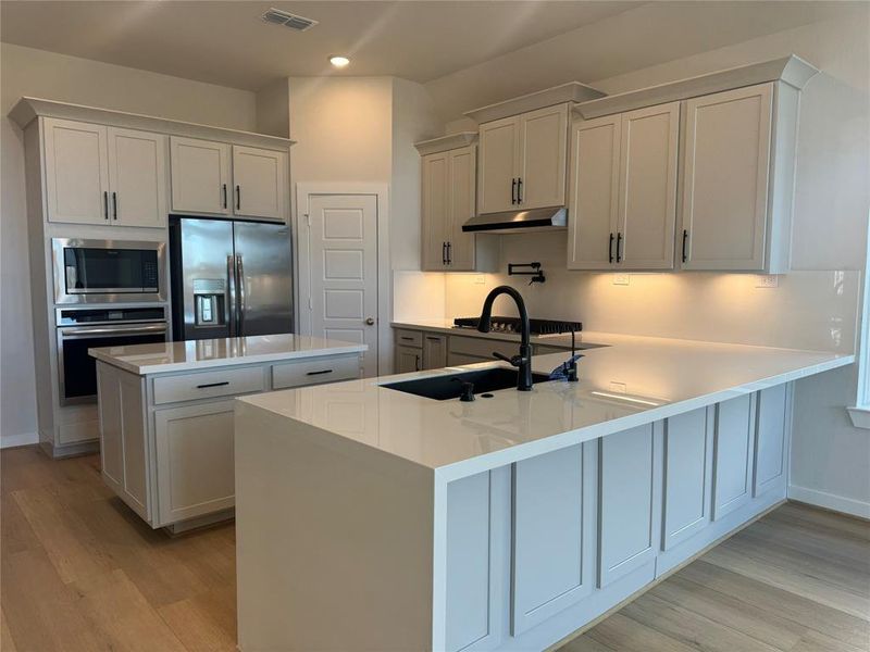 Stunning chef's kitchen includes a spice rack, pot filler, pot and pan drawer, all built-in stainless-steel Frigidaire Appliances and the refrigerator.