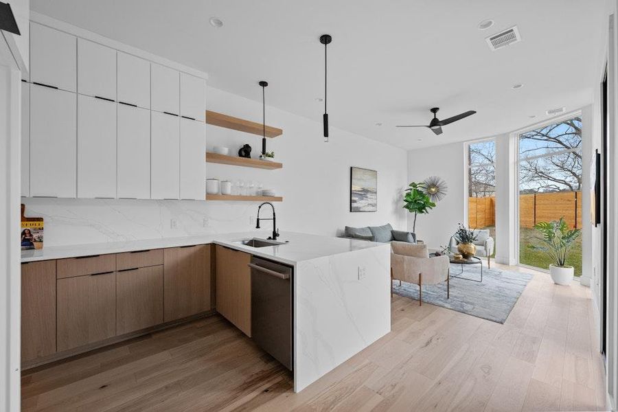 Kitchen featuring open shelves, modern cabinets, a peninsula, light stone countertops, and a wall of windows