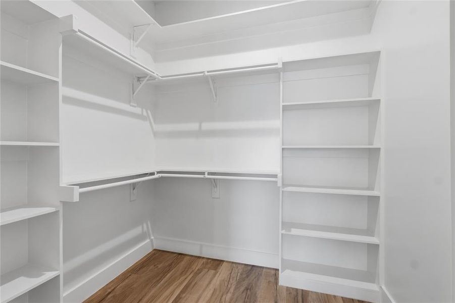Walk in closet with light wood-style floors Walk in closet with light wood-style floors