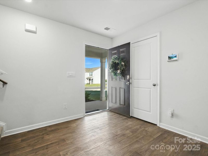 Spacious entry showcases the home's open floor plan concept with views through to main living areas. Natural light flows throughout the space highlighting the quality flooring and neutral color palette.