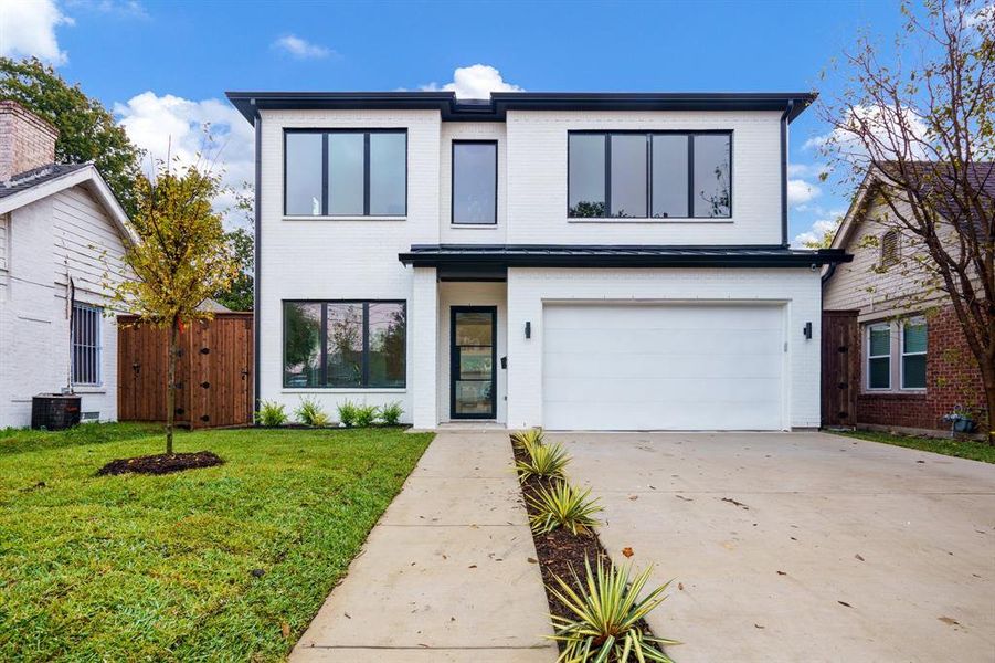 Contemporary home with a front yard and a garage