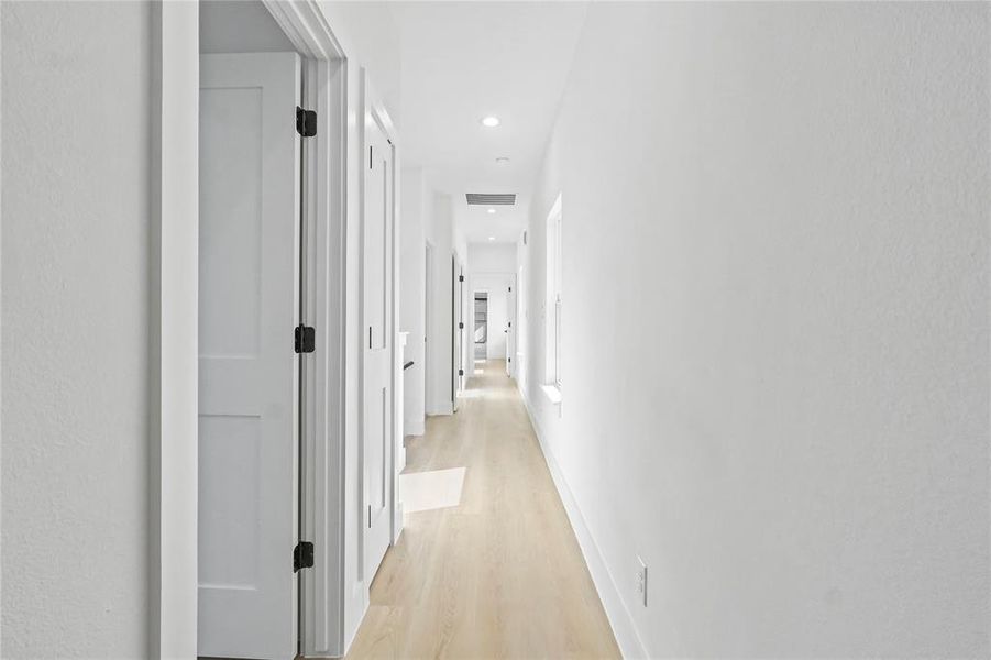 Hall with light wood-type flooring and recessed lighting