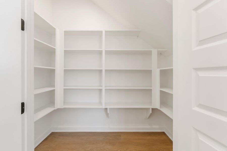 Generous walk-in pantry featuring ample shelving that offers plenty of organized storage space for all your kitchen essentials and groceries.