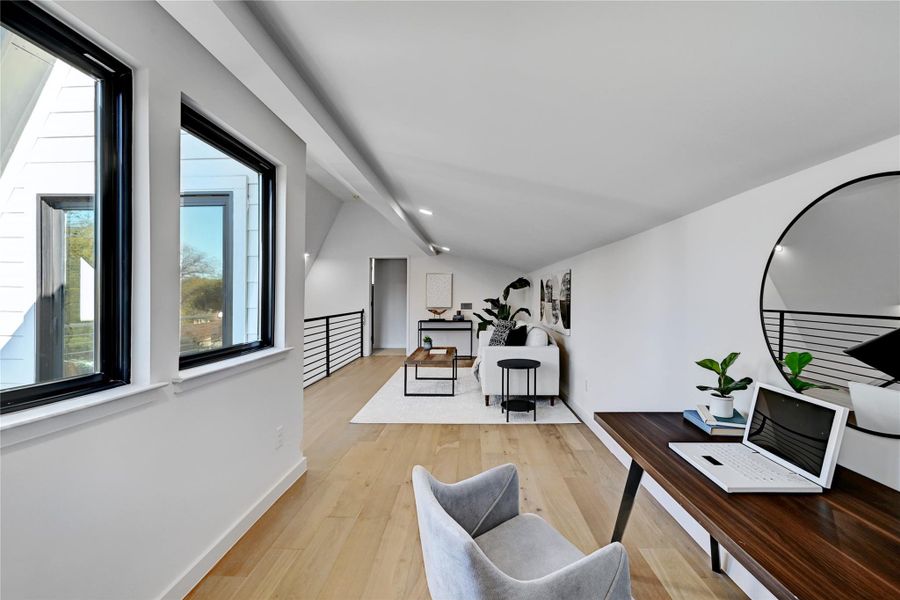 Office space featuring light wood-type flooring and vaulted ceiling