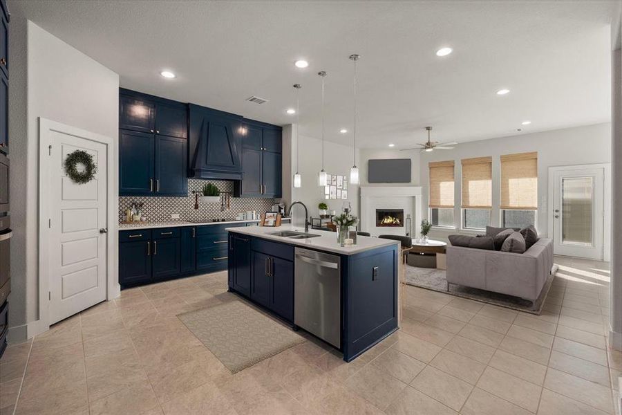 Kitchen with pendant and recessed lighting, an island with sink, dishwasher, and is open to the living area.  (Photo has been virtually staged)