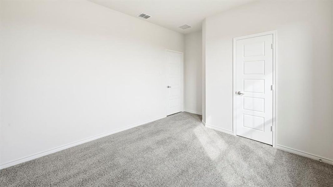 Unfurnished bedroom featuring light carpet and baseboards
