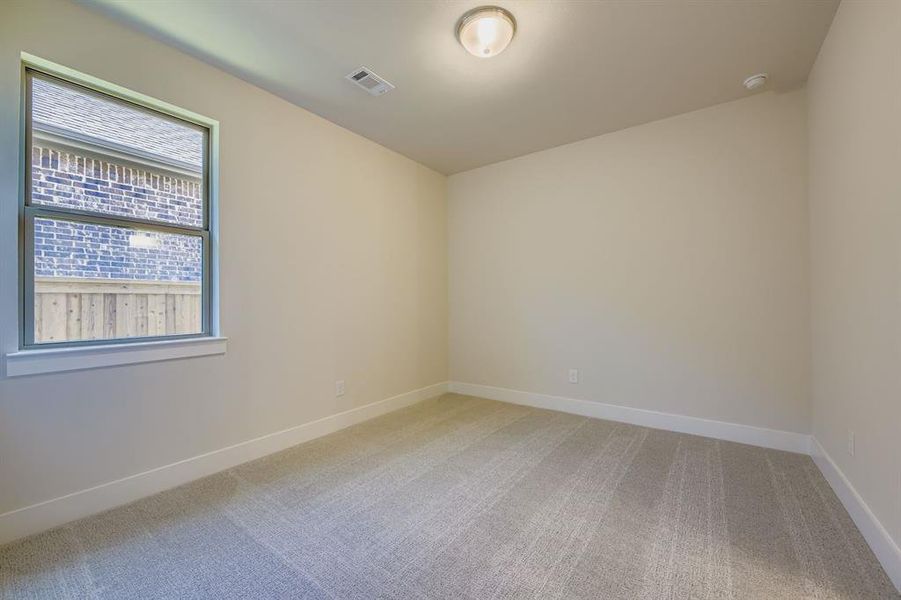 Spare room with light colored carpet and baseboards