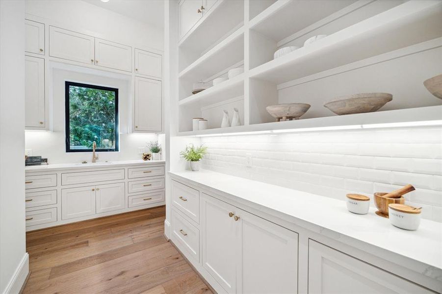 A large butler's pantry complements the kitchen, offering extensive storage to meet all culinary needs. This thoughtful addition keeps the kitchen clutter-free and ensures easy access to essential items.