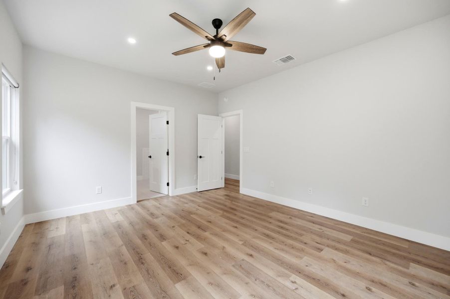 A naturally illuminated bedroom offers hardwood-style flooring and a contemporary ceiling fan for year-round comfort. A naturally illuminated bedroom offers hardwood-style flooring and a contemporary ceiling fan for year-round comfort.