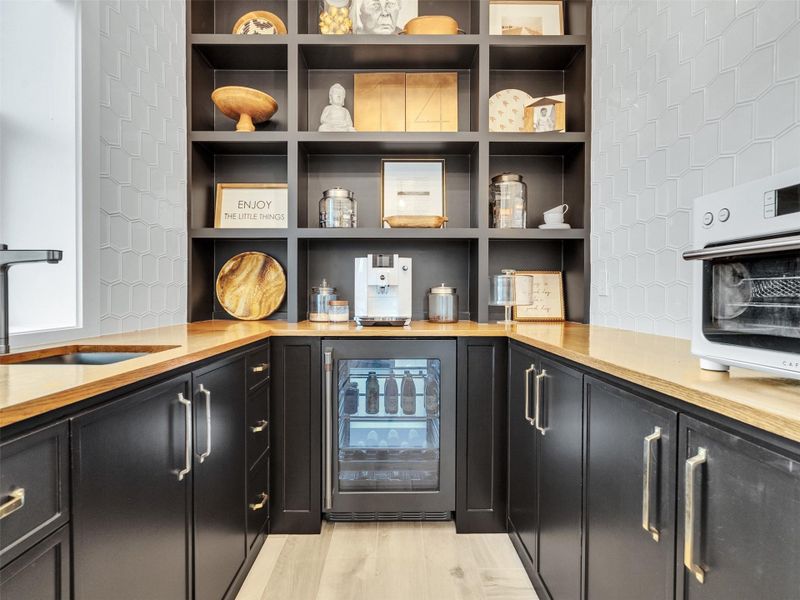 Beachside happy hour! This stunning wet bar blends sophistication and fun with herringbone tile floors, sleek countertops, Cafe appliances, and soft-close cabinetry. Perfect for mixing cocktails, brewing morning coffee, or savoring evening wine, it’s tucked inside the butler’s pantry for effortless entertaining and making every moment a little more exceptional. Beachside happy hour! This stunning wet bar blends sophistication and fun with herringbone tile floors, sleek countertops, Cafe appliances, and soft-close cabinetry. Perfect for mixing cocktails, brewing morning coffee, or savoring evening wine, it’s tucked inside the butler’s pantry for effortless entertaining and making every moment a little more exceptional.