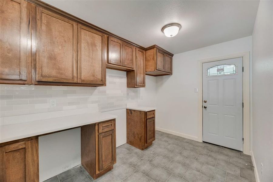 Kitchen featuring decorative backsplash and light tile patterned flooring