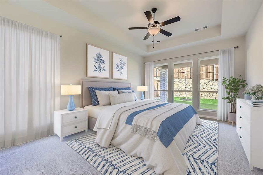 VIRTUALLY STAGED PHOTO - Carpeted bedroom featuring ceiling fan and a raised ceiling