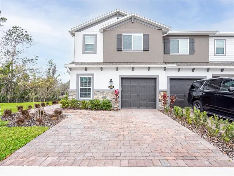 Front exterior of a new home in Towns at Tuskawilla Commons, Oviedo, FL, highlighting curb appeal (Image 22).