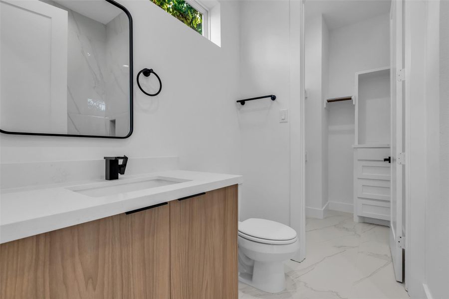 Located just beyond the bathroom, the walk-in closet provides ample space for clothing and storage. Located just beyond the bathroom, the walk-in closet provides ample space for clothing and storage.