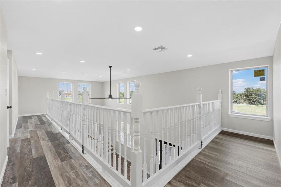 Corridor with dark wood finished floors, recessed lighting, and an upstairs landing Corridor with dark wood finished floors, recessed lighting, and an upstairs landing