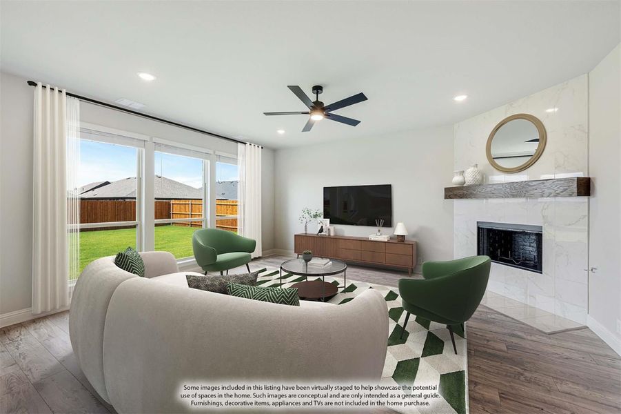 Living room with marble fireplace, ceiling fan, hardwood floors, and sliding glass doors to backyard