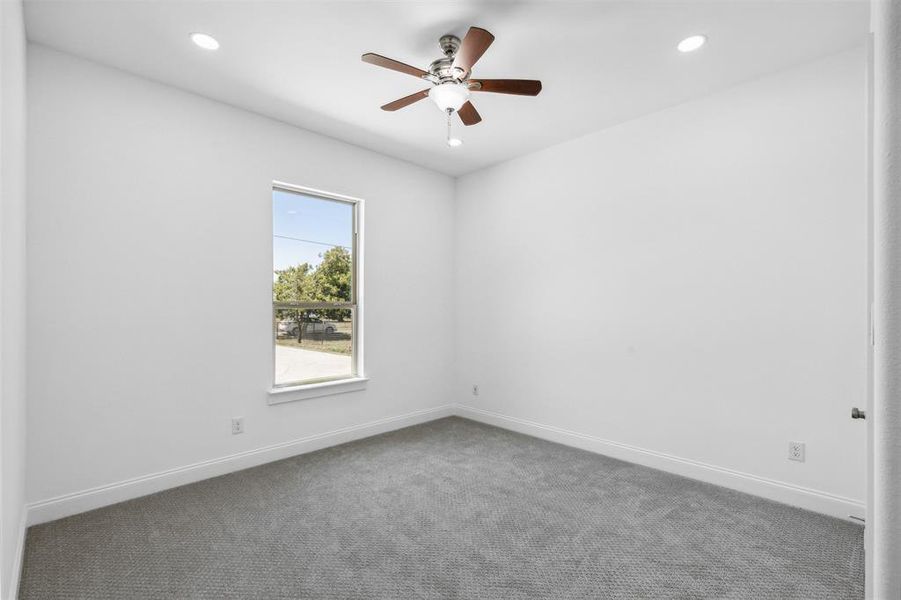 Carpeted empty room featuring ceiling fan