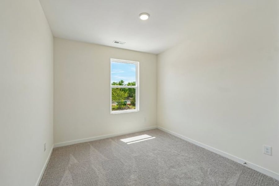 A room with a window and a carpet.