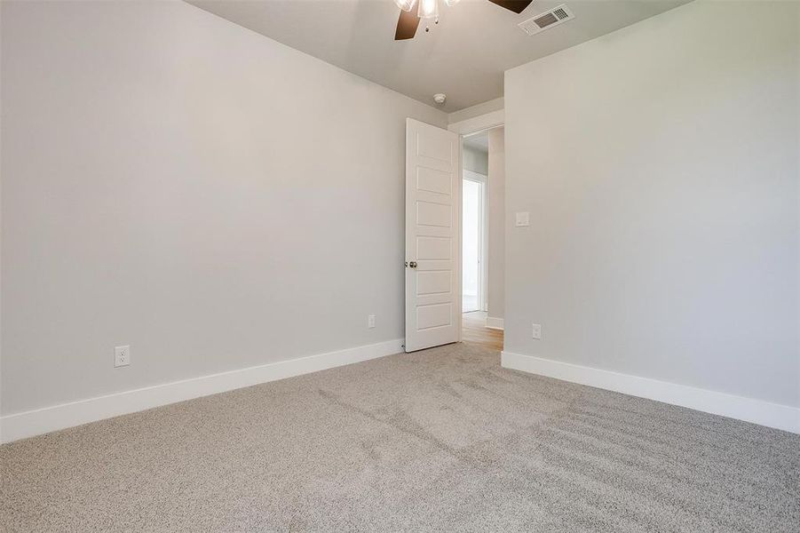 Empty room featuring carpet and ceiling fan