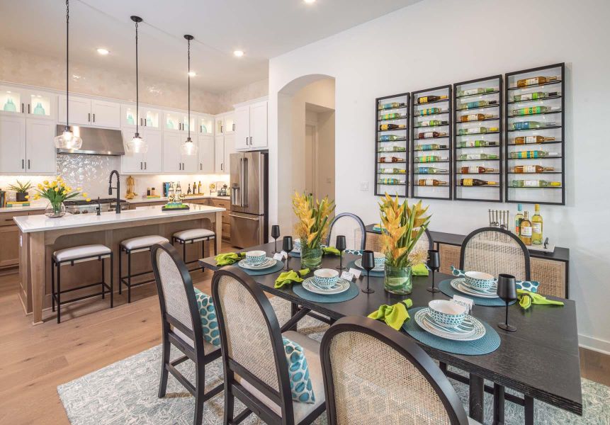 Dining space with arched walkways, recessed lighting, and light wood-style flooring