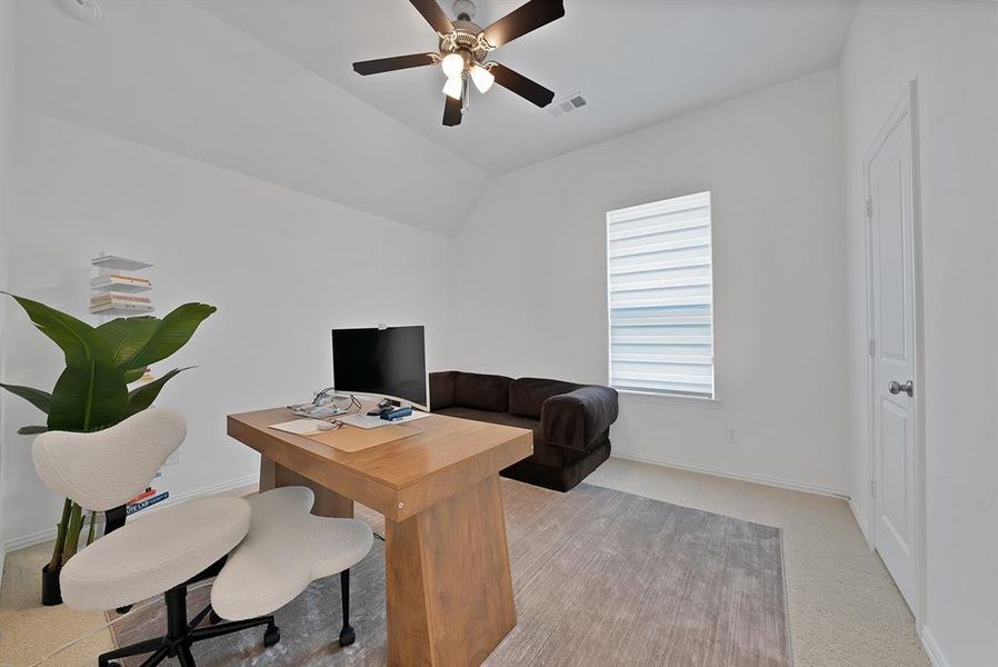 Room featuring a vaulted ceiling with a ceiling fan, a single window with blinds, and light-toned wall-to-wall carpeting