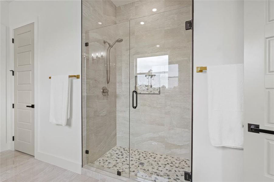 Full bathroom with a stall shower and baseboards
