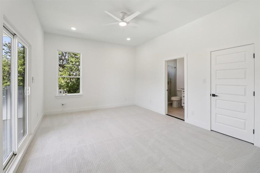 Unfurnished bedroom with light colored carpet, recessed lighting, ensuite bath, access to exterior, and a ceiling fan