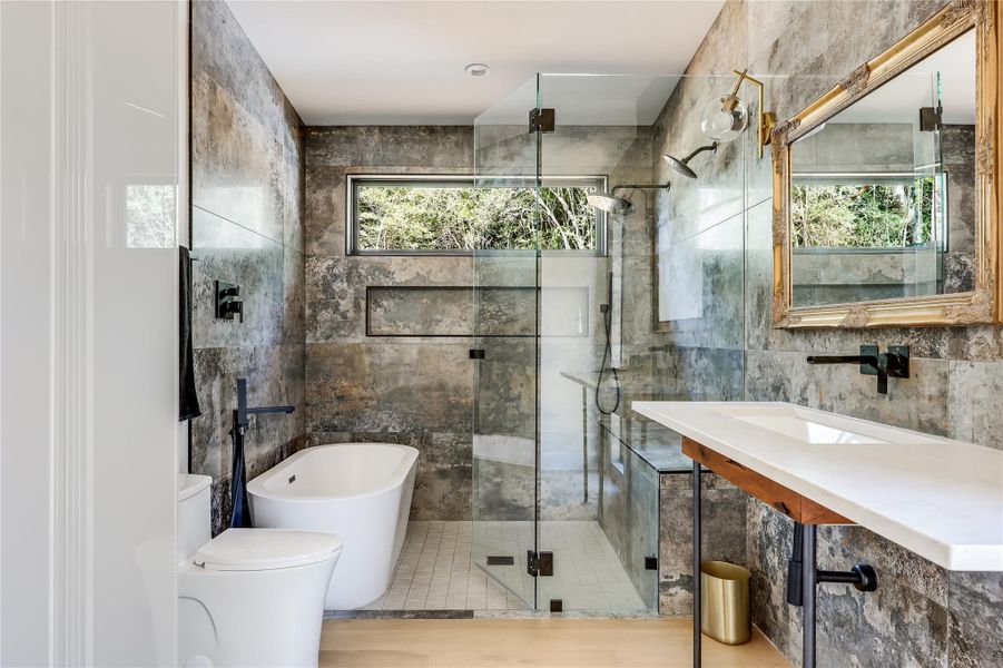 Full bath with a soaking tub, tile walls, and a stall shower