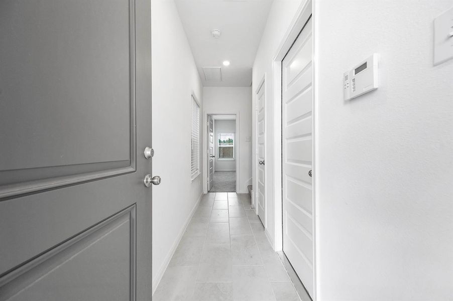 Entryway featuring the easy access to the garage, stairs, and the first floor secondary bedroom. Entryway featuring the easy access to the garage, stairs, and the first floor secondary bedroom.