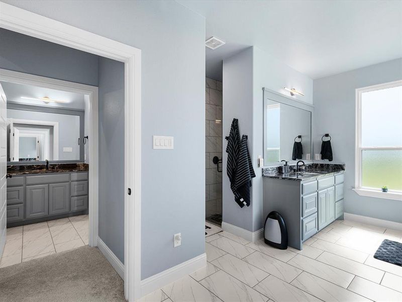 Full bathroom featuring two vanities, walk in shower, and light marble finish flooring Full bathroom featuring two vanities, walk in shower, and light marble finish flooring