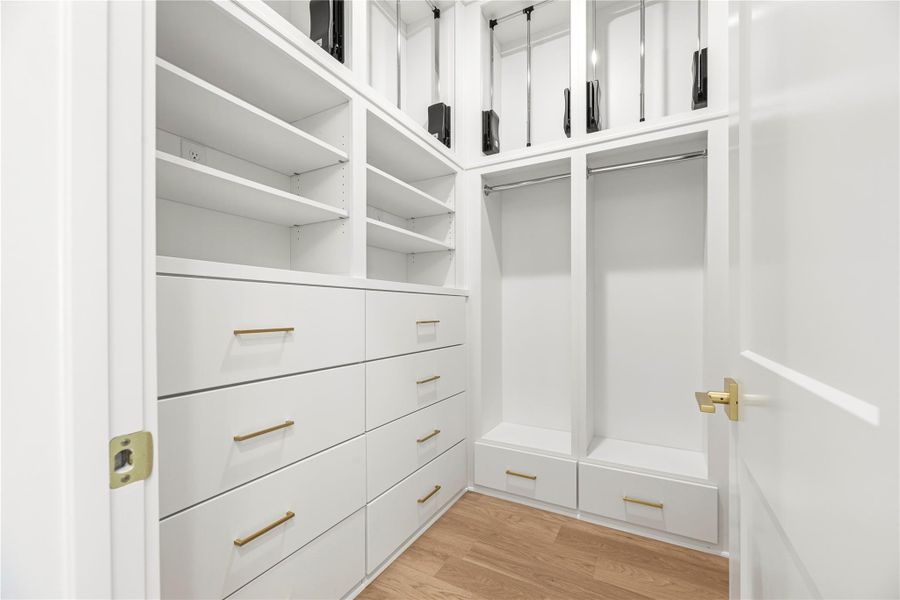 Meticulously organized, the walk-in closet boasts custom white cabinetry, soft-close drawers, and premium gold hardware, offering a highly functional and aesthetic boutique-style experience.