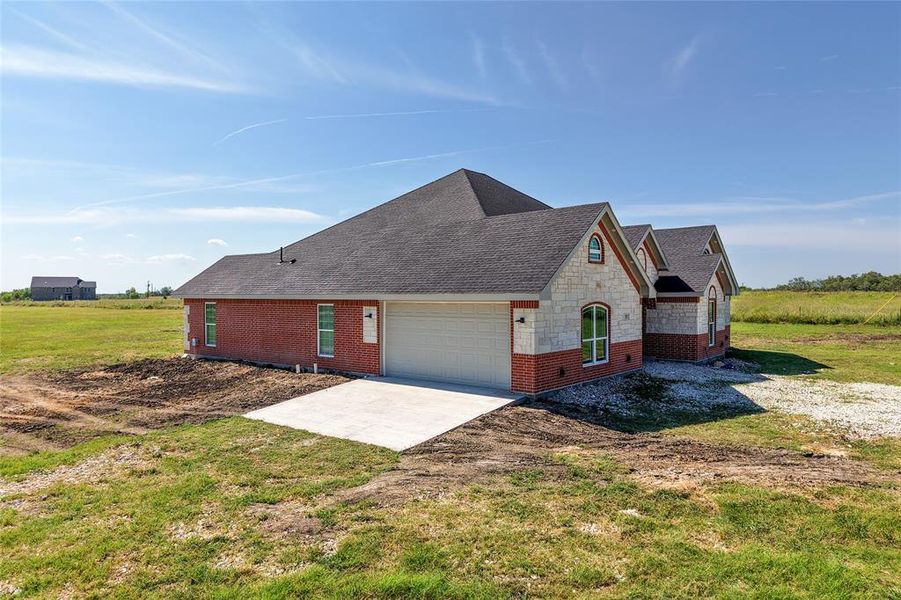 View of side of property featuring driveway and a garage