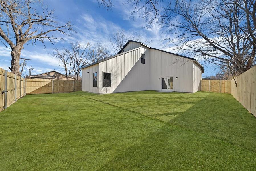 Rear view of property with a fenced backyard