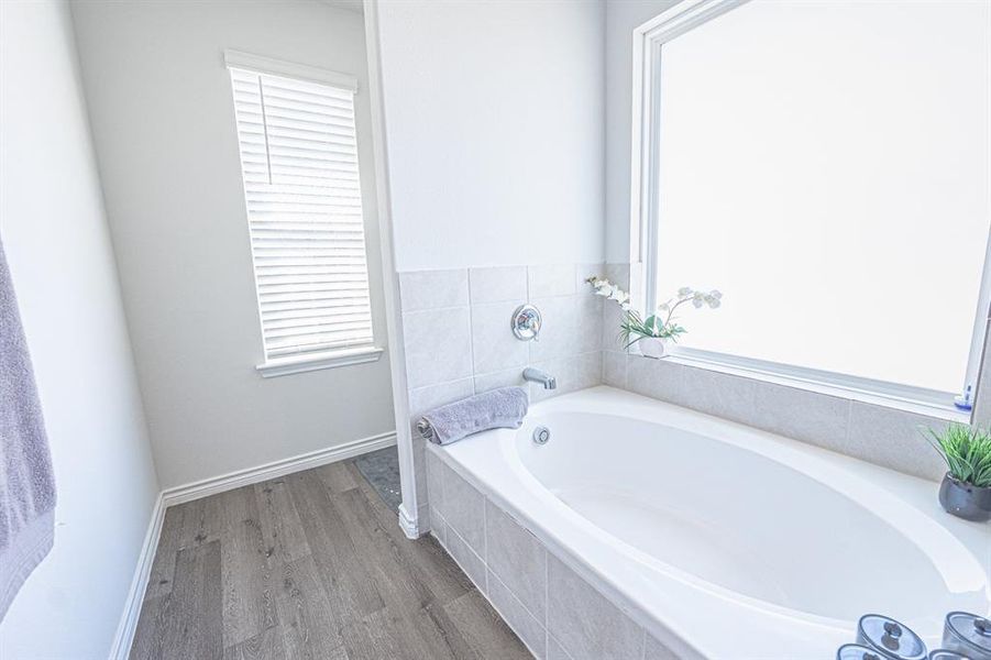 Bathroom featuring a garden tub and wood finished floors