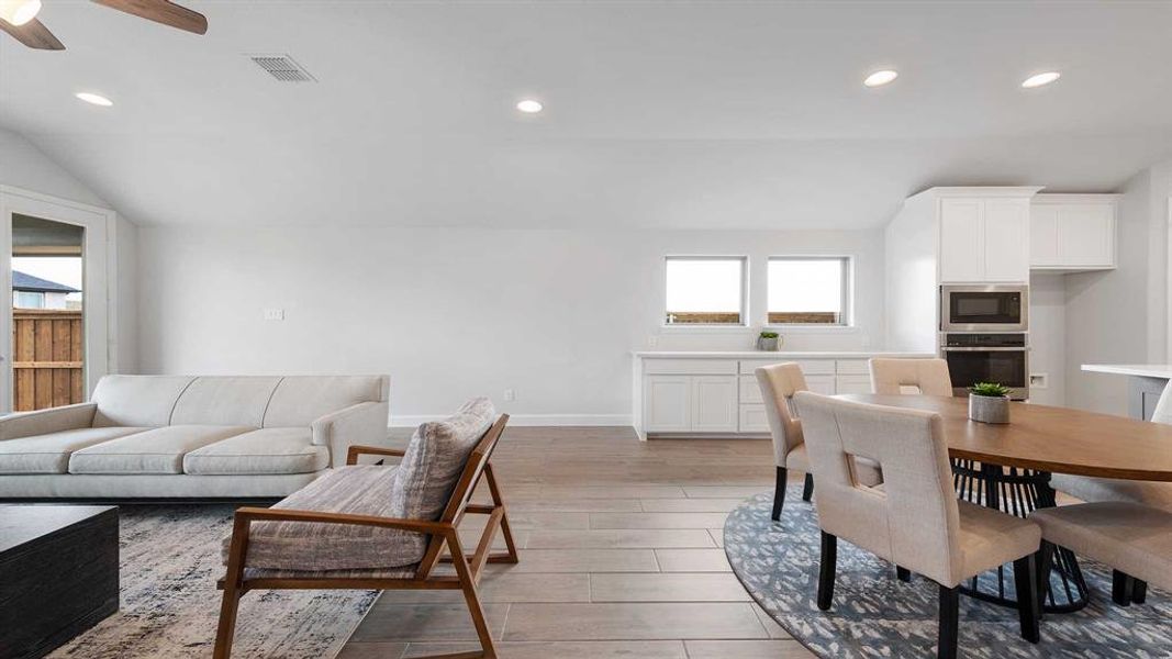 Dining area with lofted ceiling, ceiling fan, and light hardwood / wood-style floors