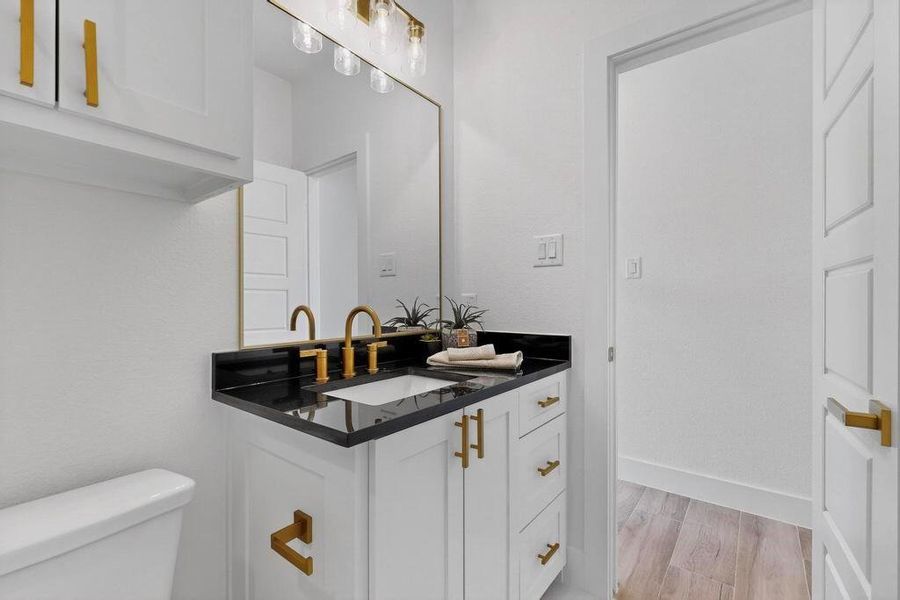 Half bath with vanity and light wood-style floors