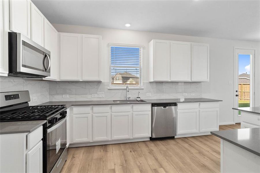 This kitchen is by far any chef’s dream! This spacious kitchen features large window, high ceilings, white stained wood cabinets, silestone countertops, SS appliances, modern tile backsplash, recessed lighting, extended counter space, and extended counter for breakfast bar, and a pantry all overlooking your huge family room.