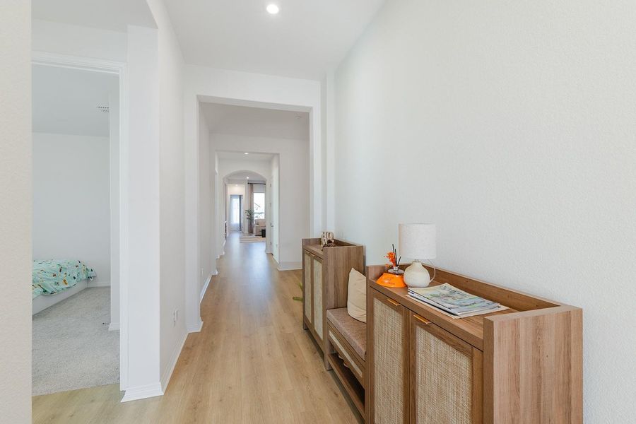 Corridor with arched walkways and light wood-type flooring