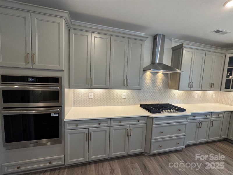 Gray cabinets and designer range hood
