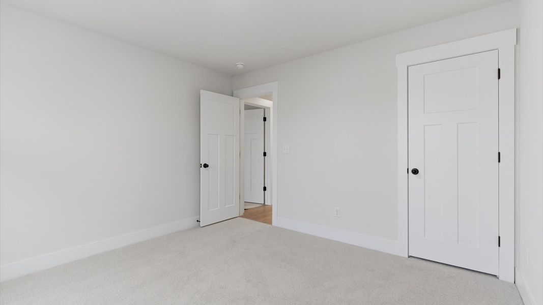 First-rate secondary bedroom with a spacious walk-in closet and elegant carpeted flooring at Pelham Crossing